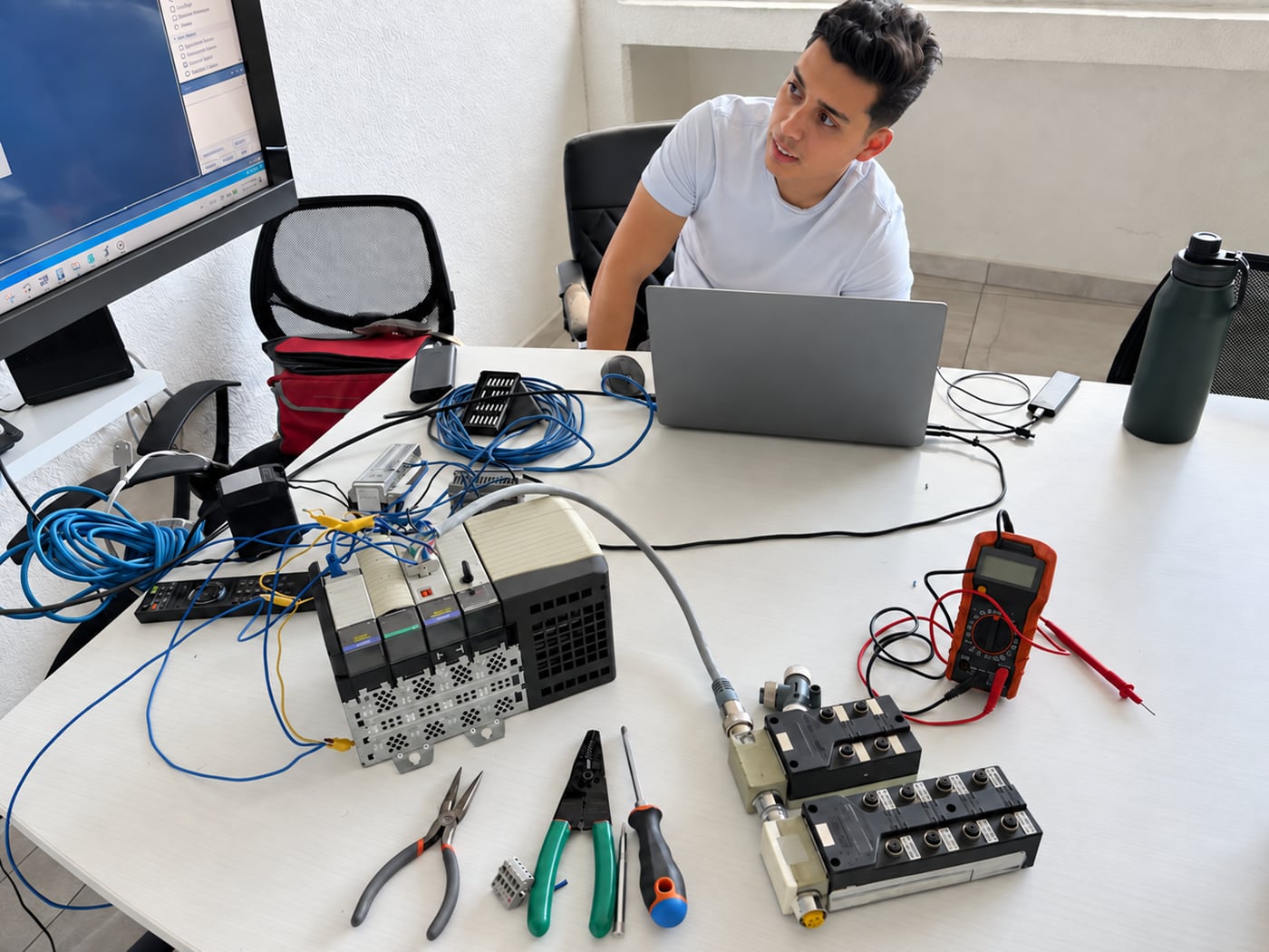 A ServTech Mexico engineer diagnosing automation equipment at a workbench.