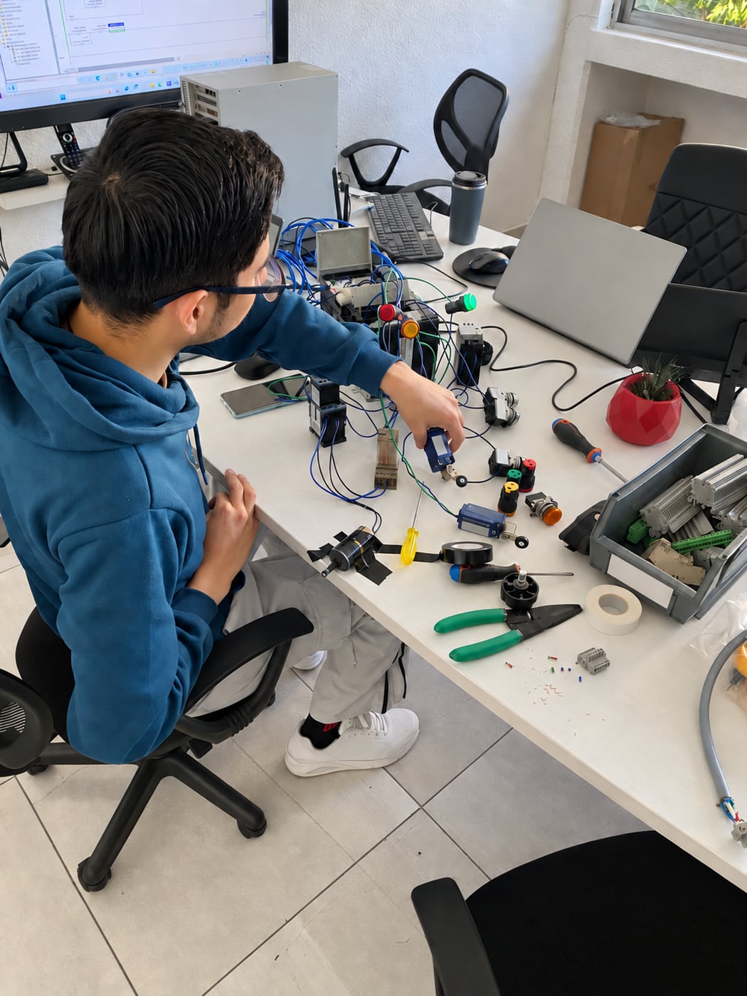 A ServTech Mexico engineer testing industrial controls at a workbench.