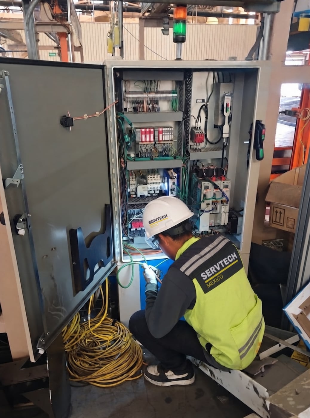 A ServTech Mexico technician servicing an industrial electrical cabinet.