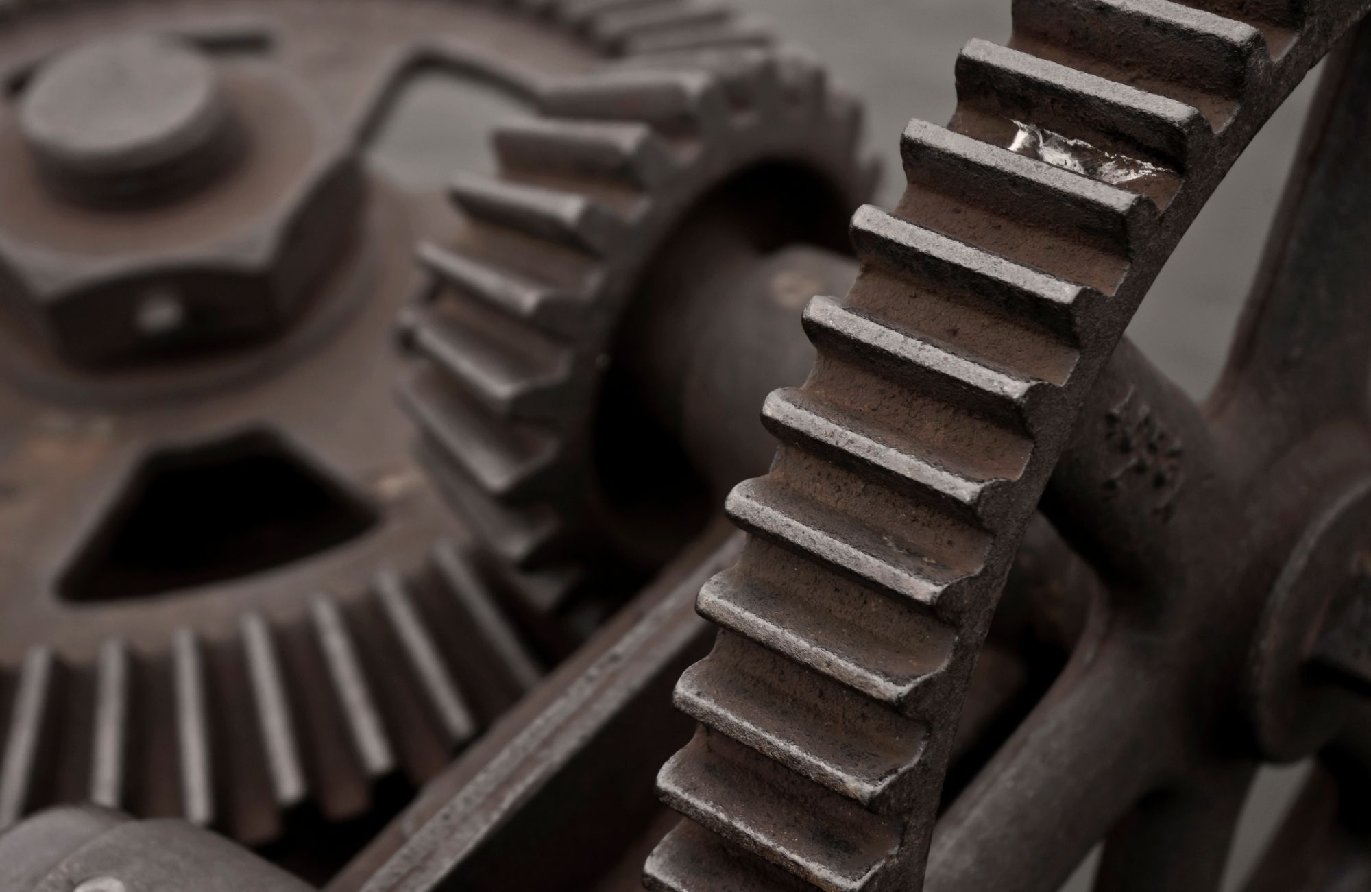 Close detail of worn steel gear teeth in mesh.